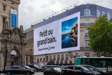 Paris, Fransa - 1 Temmuz 2023: Büyük Airbnb reklam panosu Paris 'teki bir binanın ön cephesindeki yenileme çalışmalarının iskelesini kapsıyor.