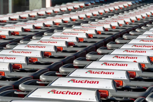 stock image Gap, France - August 6, 2023: Close-up of a row of many shopping carts branded with the logo of an Auchan store, a French company and multinational retail group