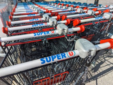 Veynes, Fransa - 06 Ağustos 2023: Fransız kooperatif ağı Systme U 'ya ait bir mağaza zinciri olan Süper U süpermarketinin logosuyla işaretlenmiş birçok alışveriş arabasının yakın çekimi