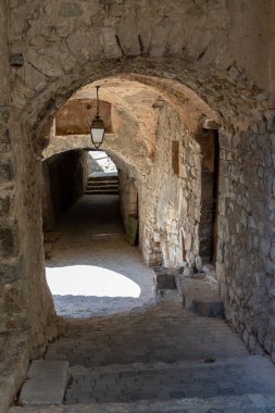 Fransa 'nın Orpierre kasabasında, Hautes-Alpes' in Fransız departmanında taştan kemerlerle kaplı eski bir cadde.