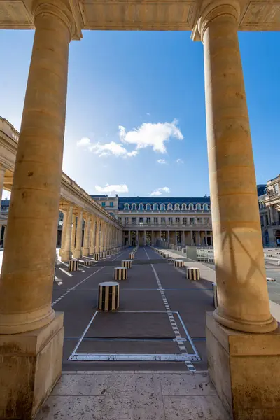 stock image Paris, France - June 15, 2024: Porticos and colonnades of the galleries surrounding the main courtyard of the Palais Royal and the Buren Columns, art installation by French artist Daniel Buren