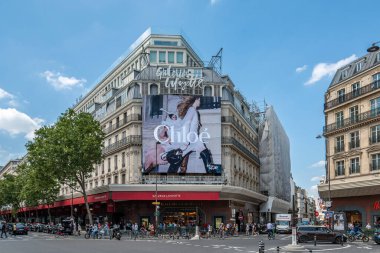 Paris, Fransa - 25 Haziran 2024: Fransa 'nın Paris şehrinin ünlü bir mağazası olan Galeries Lafayette' in dış görünüşünü kapsayan Fransız moda markası Chloe için büyük reklam panosu