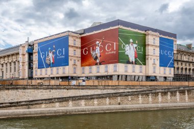 Paris, Fransa - 10 Temmuz 2024: Büyük Gucci reklam panoları İtalyan tenisçi Jannik Sinner 'ın Seine nehri kıyısındaki bir Paris binasının yenileme çalışmalarının iskelesinde oynadığı