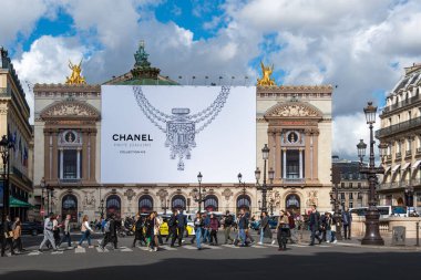 Paris, Fransa - 1 Ekim 2024: Chanel yüksek mücevher için Paris opera binasının ön cephesindeki yenileme çalışmalarını kapsayan büyük reklam panosu (Palais Garnier)