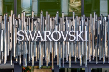 Cenevre, İsviçre - 17 Kasım 2024: Bir Swarovski mağazasının imza ve logosu. Swarovski, kristal cam mücevher ve nesneler üreten ve pazarlayan Avusturyalı bir şirket.