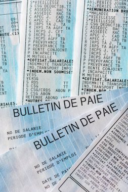 Close-up of several French pay slips ('bulletin de paie'), with some of the many lines of social security contributions and taxes paid by employees and employers in France clipart