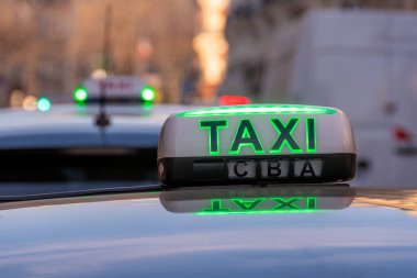 Fransa 'nın başkenti Paris' te bir caddede park halindeki bir taksi durağına park edilmiş bir araca yeşil (ücretsiz taksi) ile aydınlatılmış 