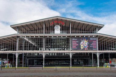 Paris, Fransa - 4 Mart 2025: Büyük Halle de la Villette 'in cephesi, eski Paris mezbahalarından bir bina, şimdi kültürel etkinliklere, ticaret fuarlarına ve toplantılara ev sahipliği yapan bir salon.