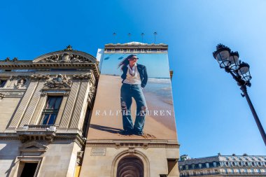 Paris, Fransa - 9 Nisan 2025: Ralph Lauren için Paris Opera binasının ön cephesindeki restorasyon çalışmalarını kapsayan büyük reklam panosu (Palais Garnier)