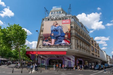 Paris, Fransa - 14 Mayıs 2025: Fransa 'nın Paris şehrinin ünlü mağazası Lafayette Galerisi' nin ön yüzünü kaplayan bir İtalyan moda markası olan Diesel için büyük reklam panosu
