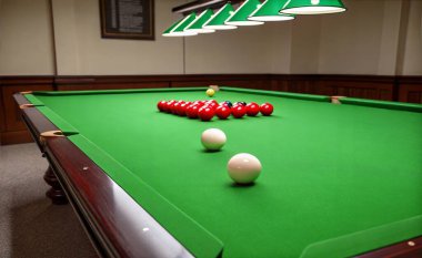 Süs olarak yeşil bir Snooker masası olan loş bir oda. Işık yumuşak ve eşit dağılmış. Sahne boyunca yumuşak bir parıltı yaratır. 