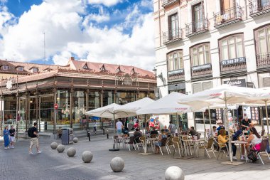 Madrid, İspanya - 20 Haziran 2022: Şemsiyelerin altındaki masalarla San Miguel pazarının önündeki plaza