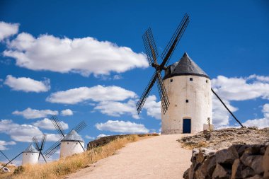 Consuegra 'nın üç yel değirmeni mavi gökyüzü ve beyaz bulutlar (İspanya)