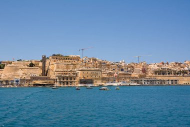 Valletta, Malta - 17 Haziran 2023: Valletta ve Vittoriosa arasında geçen botlar ve arka planda tipik luzzu ve Valletta