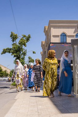 Semerkant, Özbekistan - 06 Temmuz 2024: Şehrin sokaklarında geleneksel giysiler içinde yürüyen kadınlar