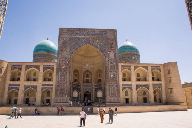 Buhara, Özbekistan - 09 Temmuz 2024: Mir-i Arap Madrasa, gündüz ve Buhara meydanında turistlerle