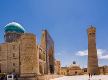Buhara, Özbekistan - 09 Temmuz 2024: Kalon medresesinin minare ve kapılarına sahip antik meydan