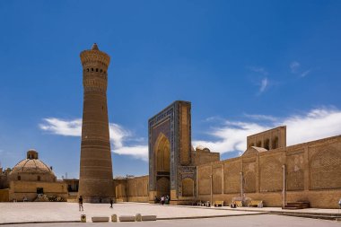 Buhara, Özbekistan - 09 Temmuz 2024: Kalon medresesinin minare ve kapılarına sahip antik meydan