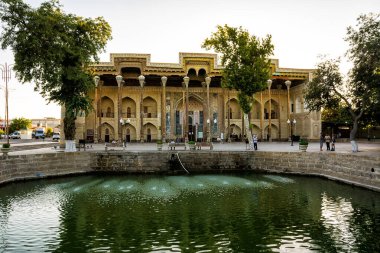 Buhara, Özbekistan - 09 Temmuz 2024: Bolo Hauz, Buhara 'daki tarihi cami, Özbekistan' ın önünde tipik gölet (hauz) bulunuyor