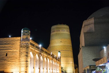 Khiva, Özbekistan - 10 Temmuz 2024: Kalta Minaret, Özbekistan 'da Khiva sokaklarında gece aydınlandı.