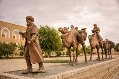 Khiva, Özbekistan - 11 Temmuz 2024: Bir kervanı temsil eden bronz heykel kurulumu, develer ve antik ticaret yolları ve Orta Asya göçebelerinin anısına bir rehber.