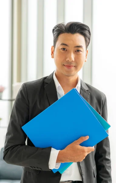 Retrato Empresário Atraente Terno Segurando Pasta Azul Empresa Dentro Escritório — Fotografia de Stock