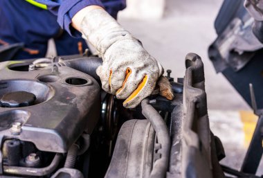 Motor soğutucu miktarını kontrol eden tamirci elleri yakın çekimde. Teknisyen kamyon, araba ya da aracın motorunu inceler ve bakımını yapar. Araba tamir servisi, araba tamircisi..