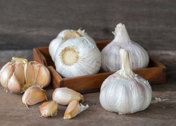 Garlic bulbs and cloves on vintage wooden background.