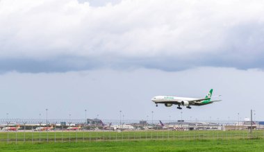 Samut Prakan, Tayland: 30 Temmuz 2023: Evaair uçağı Suvarnabhumi uluslararası havaalanı arka planında bir hava trafik kontrol kulesiyle iniş ve kalkışa hazırlanıyor.