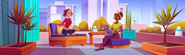 二人の女性が大都市のテラスで話している 膝の猫と椅子に座っている女性の友人のベクトル漫画のイラスト 居心地の良い家具やランプと都市のアパートのバルコニー 都市景観 — ストックベクタ