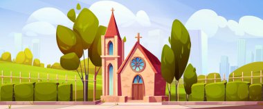 Kırmızı çatılı ve yeşil çayırlı bir kilise binası. Katolik kilisesi, vitray pencereli ahşap kapılı, taş basamaklı, ağaçlarla çevrili ve şehir arka planındaki çitlerle çevrili..