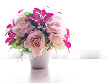 Masadaki pembe renkli yapay gül buketi, metin için fotokopi alanı, güzel arka plan ya da duvar kağıdı, anneler günü, natürmort hayat, kadınlar günü şenlik arka plan, zarif arkaplan. 