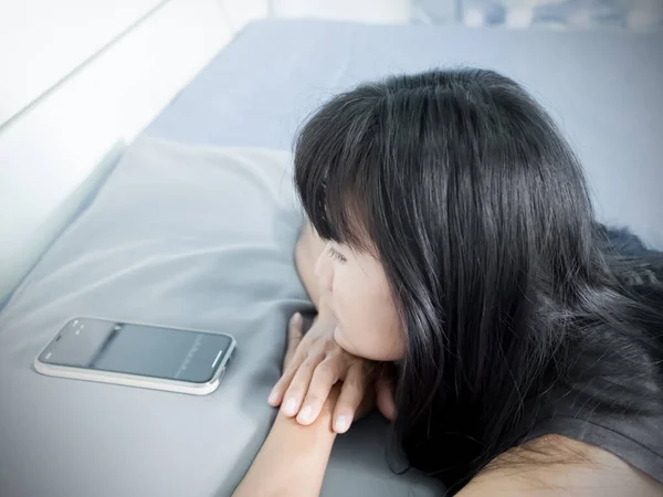女人睡在床上 晚上看手机 她带着悲伤和压力从丈夫那里等待回电 女孩伤心破碎的心和问题 真实的黑头发和亚洲皮肤 — 图库照片