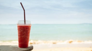 Bulanık Mavi Deniz ve Mavi Gökyüzü Arkaplanda Karpuz Kırmızı Meyve Smoothie, Yaz İçeceği Tatlı Kokteyli Atıştırmalık Tropikal, Diyet Bitkisi Doğal Sağlıklı Meyve Suyu Sebze Suyu.