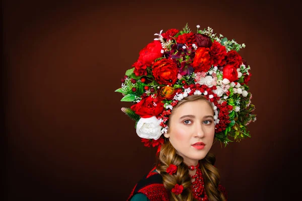 花の花輪と彼女の頭の上に赤いバラの束と美しい若い女の子の肖像画 — ストック写真