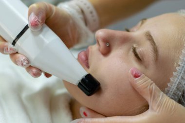 Genç bir kız için yüz masajı yapan bir güzellik uzmanı.  