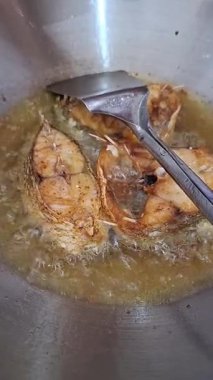 Kızartma tavası ve spatulada kızartılmış balık videosu.