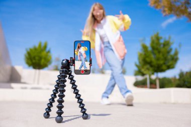 Genç kız cep telefonuyla kendini videoya çekiyor.