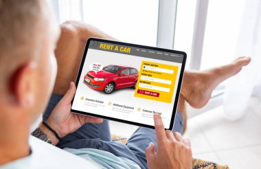 Kiralık araba kiralama sitesini tablet bilgisayarda gören adam
