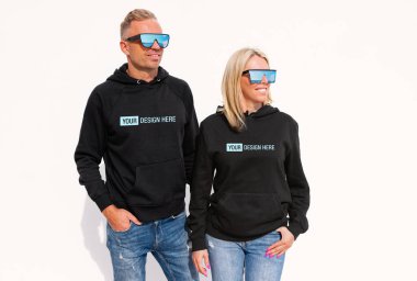 Woman and man wearing black hoodies, mockup for your custom hoody sweatshirt design clipart