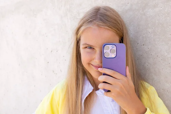 十代の女の子保持携帯電話のカメラの前で彼女の目 ストック写真