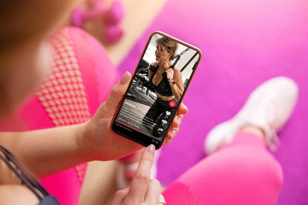 观看社交媒体分享的健身视频的女性 图库照片