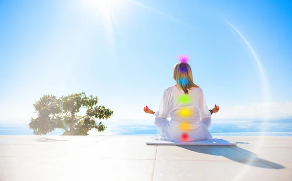 女性は屋外で瞑想 人体の7つのエネルギーチャクラの概念 ストックフォト