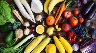 Meyve ve sebze ahşap arka plan üzerinde beyaz, sarı, yeşil, turuncu, kırmızı, mor. Sağlıklı gıda. Çok renkli çiğ gıda.