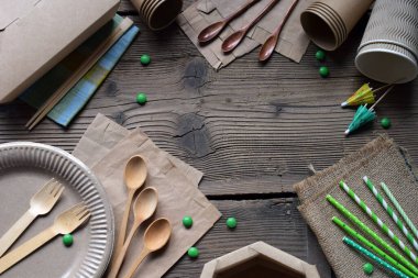 Yeşil Yaşam için sürdürülebilir ahşap ve kağıt gereçleri. Biyolojik çözünebilir tek kullanımlık tabaklar, bardaklar, yemek çubukları ve peçeteler Çevresel Bilinçli Yemek Çözümleri için kırsal ahşap masa üzerine dizilmiş.