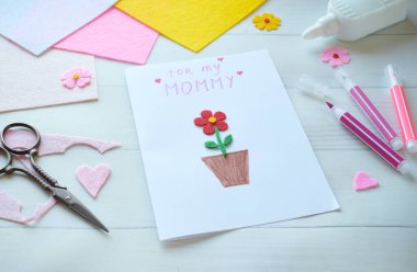 El yapımı anneler günü tebrik kartı oluşturma. Keçeli Çiçekler, Renkli Kağıt ve Beyaz Tahta Arkaplanda Makas Projesi. Annem için Yaratıcı Tatil Hediyesi Fikri, El işi Malzemeleri ile Kartvizit Yapımı Süreci