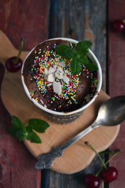 Üzerine krem şantili krema serpilmiş çikolatalı tatlı ve naneli kahve fincanı kırsal ahşap tahtalarda servis edilen tatlı kafe menüleri fırın reklamları ve sıcak yemek sunumları için mükemmel.