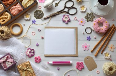 El yapımı DIY çalışma alanı düz yatıyordu iplik ipliği makas kancalar ve renkli aksesuarlar beyaz ahşap bir yüzey üzerinde zanaatkar zanaat ve hobi projeleri için mükemmel