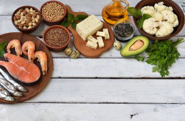 Beyaz kırsal yüzeyde deniz ürünleri, tohumlar, fındıklar, sebzeler ve yağ da dahil olmak üzere çeşitli omega 3 zengin gıdaların en üst görüntüsü. Temiz yemek, beyin fonksiyonları, kalp desteği, doğal sağlıklı beslenme ve yaşam tarzı kavramı.