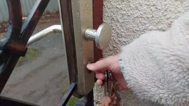 Kürk kollu kadın gündüz vakti sokak girişinde yuvarlak saplı metal kapıyı açar. Özel mülke girme kavramı, fiziksel eylem, günlük an, gelişigüzel kentsel yönlendirme